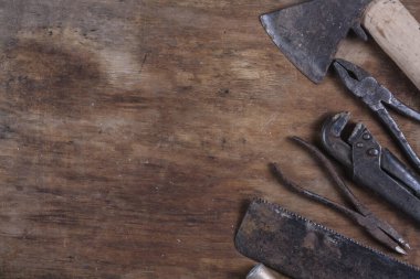 Old rusty construction tools on a brown wooden table 