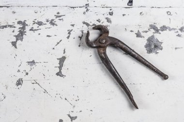 Gri bir demir zemin üzerinde eski paslı inşaat aletleri 