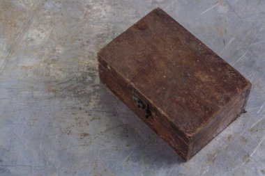 Gri demir bir masa üzerinde demir kilidi olan eski, eski bir tahta kutu. 