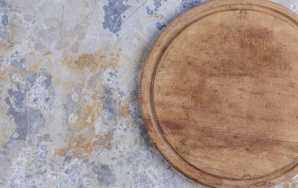 Mutfağa yakın çekim, eski püskü demir bir uçakta kahverengi bir tahta kesme tahtası.