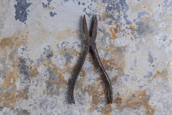 Old rusty construction tools on a gray iron background