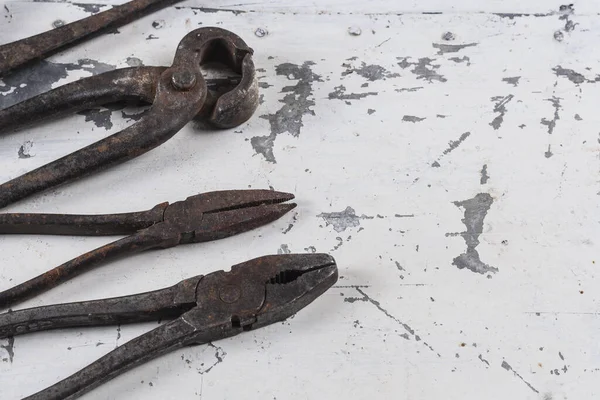 Gri bir demir zemin üzerinde eski paslı inşaat aletleri 