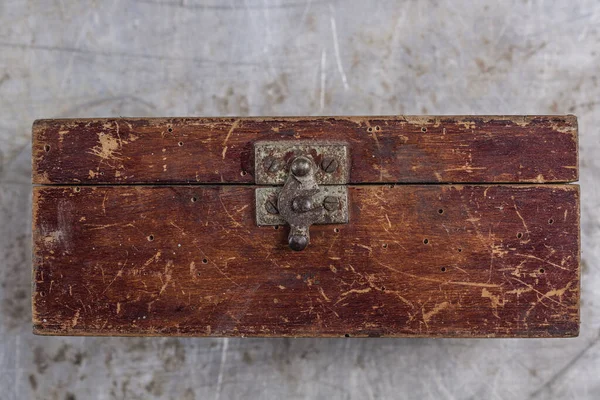 Gri demir bir masa üzerinde demir kilidi olan eski, eski bir tahta kutu. 