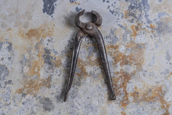 Gri bir demir zemin üzerinde eski paslı inşaat aletleri 