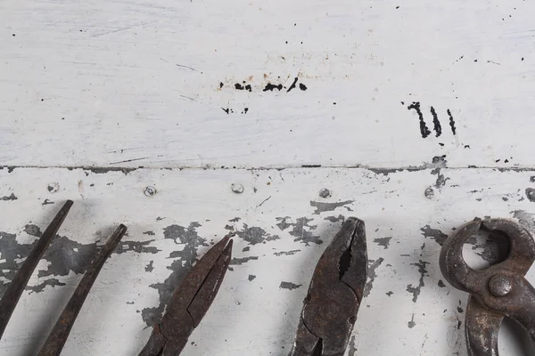 Gri bir demir zemin üzerinde eski paslı inşaat aletleri 