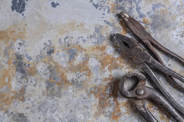 Old rusty construction tools on a gray iron background