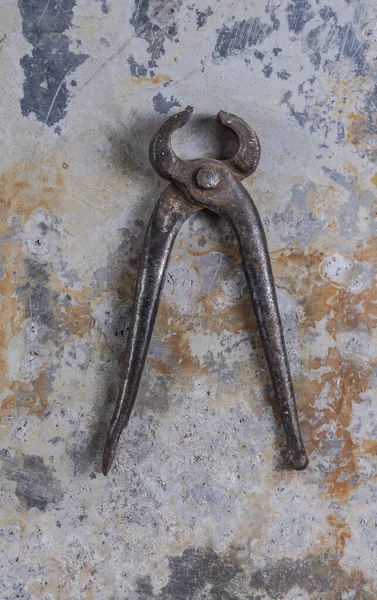 Gri bir demir zemin üzerinde eski paslı inşaat aletleri 