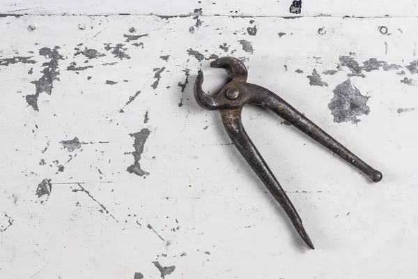 Gri bir demir zemin üzerinde eski paslı inşaat aletleri 