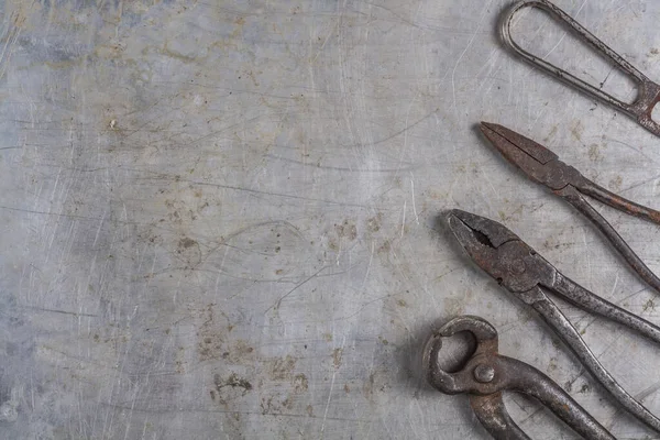 Old rusty construction tools on a gray iron background