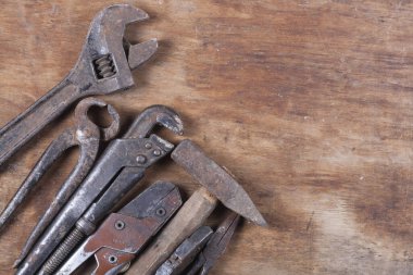 Eski inşaat aletleri. Ahşap bir masa üzerinde bir sürü pas ve çizik var.