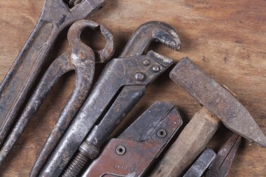 Eski inşaat aletleri. Ahşap bir masa üzerinde bir sürü pas ve çizik var.