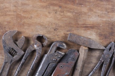 Old construction tools a lot of rust and scratches on a wooden table Closeup