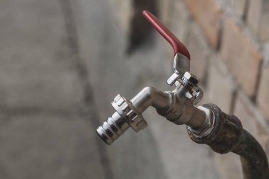 Aluminum faucet to turn on the water with a red switch and water the garden or greenhouse plants