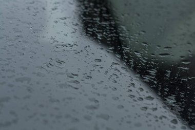 Siyah demir bir uçakta yağmur damlaları. Yakın plan.