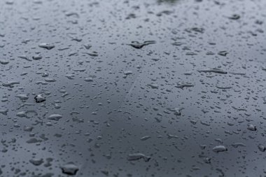 Siyah demir bir uçakta yağmur damlaları. Yakın plan.