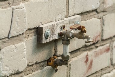 Old iron faucet close-up on a brick wall