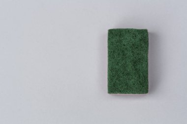 Multicolored sponge for washing dishes on a solid gray background, close-up