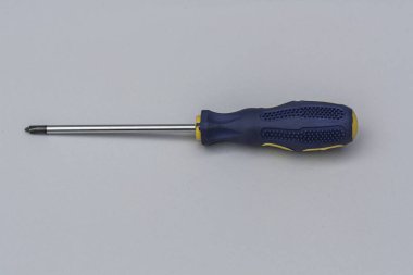 Repair Phillips screwdriver and blue handle close-up on a gray background, top view