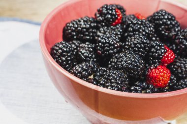 Blackberry berries close-up in a pink plate