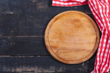 Round kitchen stand for cutting products and a red and white towel on a wooden background