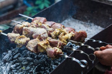Cooking meat on skewers on the grill close-up. Pork meat in spices at the stake