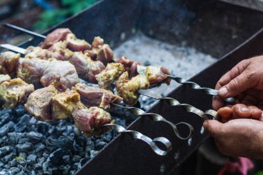 Cooking meat on skewers on the grill close-up. Pork meat in spices at the stake
