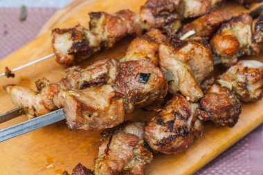 Grilled fried meat and vegetables on a wooden stand. top view close-up