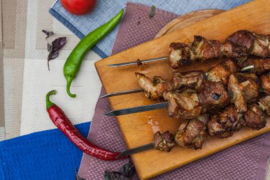 Grilled fried meat and vegetables on a wooden stand. top view close-up