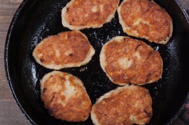 Fried chicken cutlets on a black frying pan close-up, fried meat products, home cooking