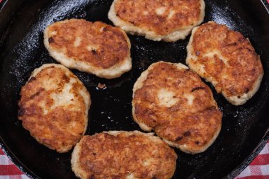 Fried chicken cutlets on a black frying pan close-up, fried meat products, home cooking