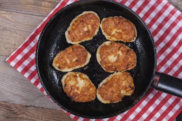 Fried chicken cutlets on a black frying pan close-up, fried meat products, home cooking
