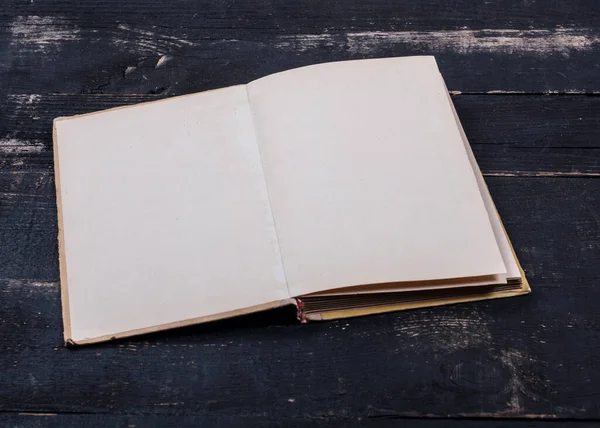 一本用黄页写在黑色木制桌子上的旧书 上面有文字的空间 一本古籍的特写 — 图库照片