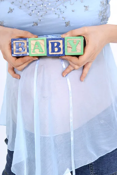 Blocos de ortografia bebê acima esperando barriga da mãe — Fotografia de Stock