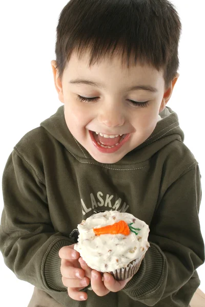 Jongen eten wortel cupcake Rechtenvrije Stockfoto's