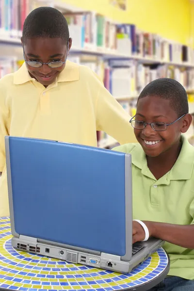 Due studenti neri del handsom al computer portatile nella biblioteca della scuola — Foto Stock