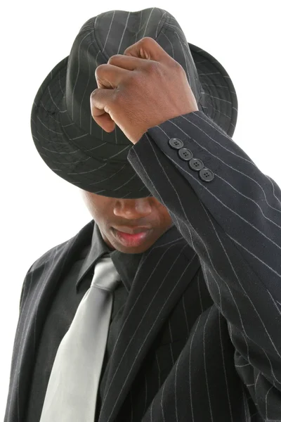 Attraente giovane uomo in gessato vestito ribaltamento il suo cappello — Foto Stock