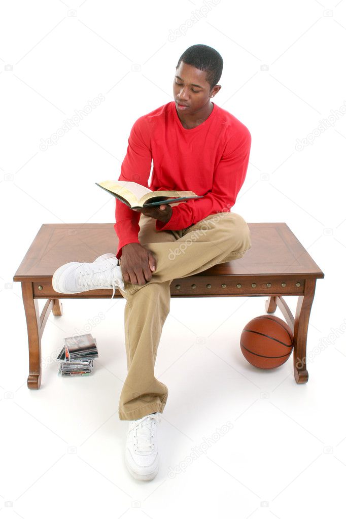 Casual Man Sitting on Table Reading Book