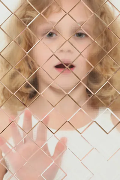 Criança autista embaçada atrás do painel de vidro — Fotografia de Stock