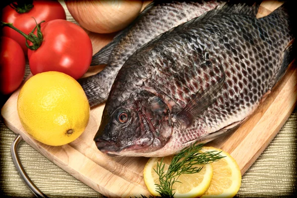 Dos peces crudos de tilapia en estilo vintage Fotografía en la tabla de cortar — Foto de Stock