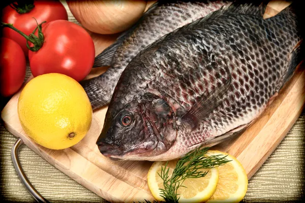 Twee rauwe tilapia vis in vintage stijl foto op snijplank Rechtenvrije Stockafbeeldingen