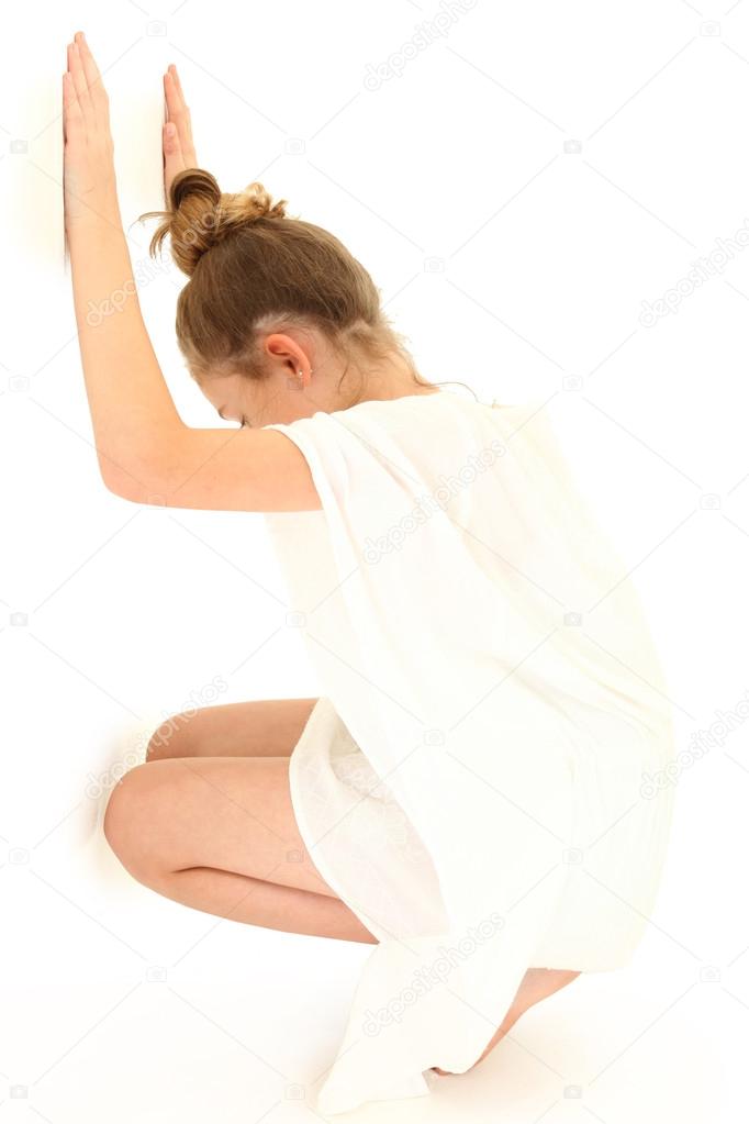 Tween Girl Hiding Against White Wall