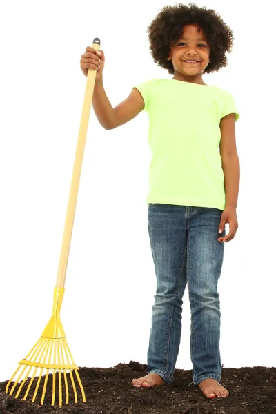 美丽的黑人女孩儿童用耙子站在污垢 — 图库照片