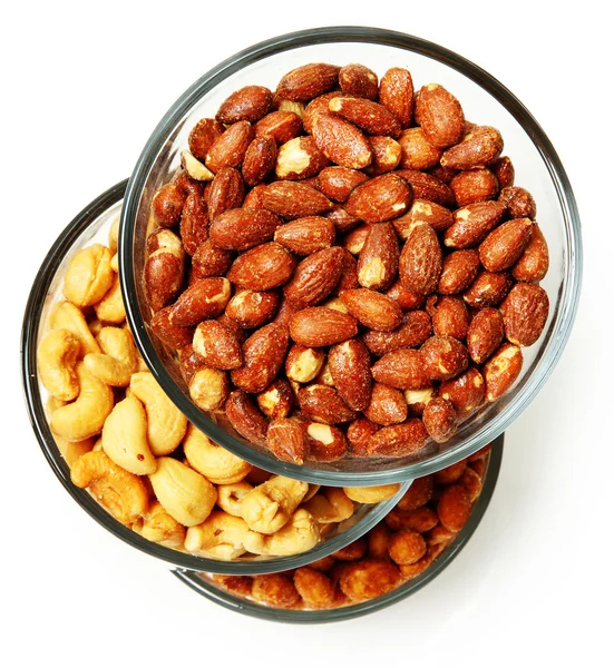 Three glass bowls filled with cashews, salted roasted almonds an — Stock Photo, Image