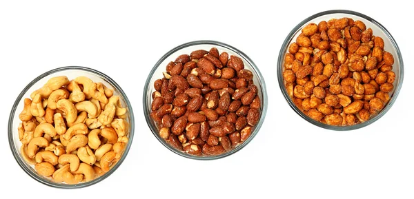 Three glass bowls filled with cashews, salted roasted almonds an — Stock Photo, Image