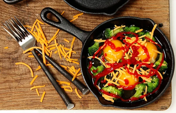 Uncooked Raw Eggs in Skillet with Brocolli, Cheese and Sriracha — Stock Photo, Image