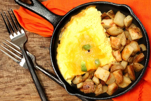 Denver Omelette and Ranch Potatoes in Cast Iron Skillet on Table — Stock Photo, Image