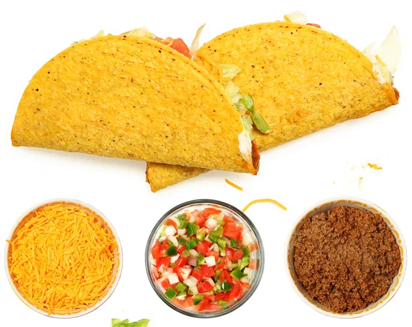 peynir ve salata ile beyaz zemin üzerine yığılmış iki tacos