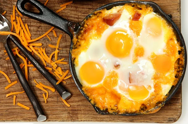 Сковорідку запечений яйця та ковбаси з сиром Ліцензійні Стокові Зображення