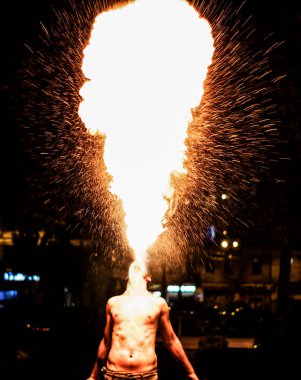 man fakirk spewing flames