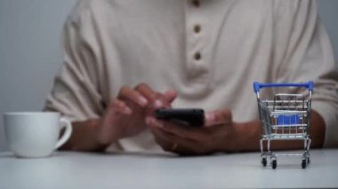 stop motion a men shopping online with smart phone and a cart shopping moving.